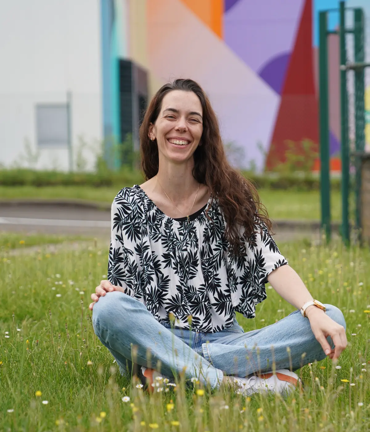 Alexia Nectoux, portrait souriant, assise dans l'herbe